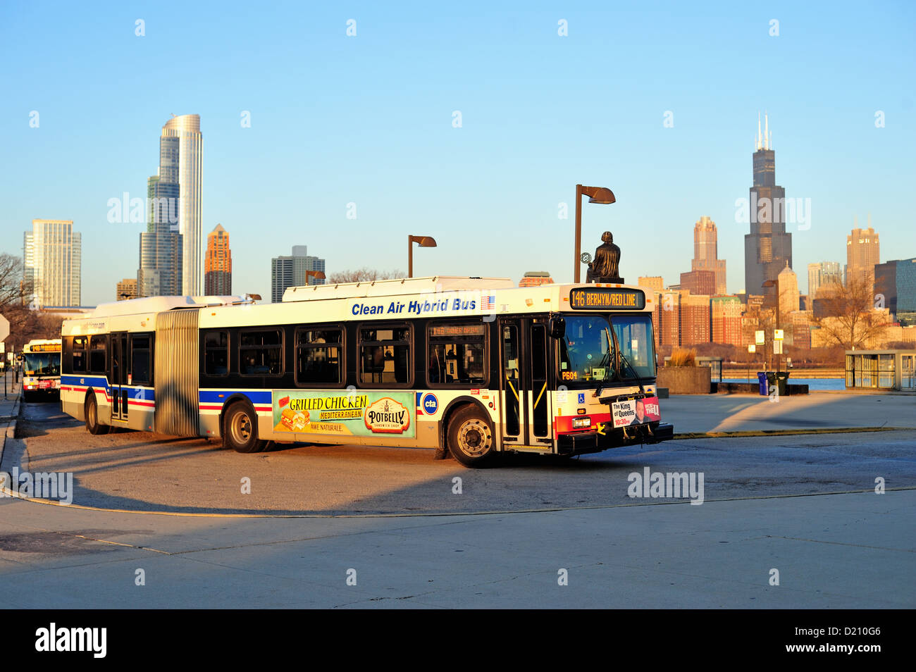 USA Illinois Chicago rising sun reflects off the front of a CTA bus turning at Chicago's Museum Campus. Chicago, Illinois, USA. Stock Photo