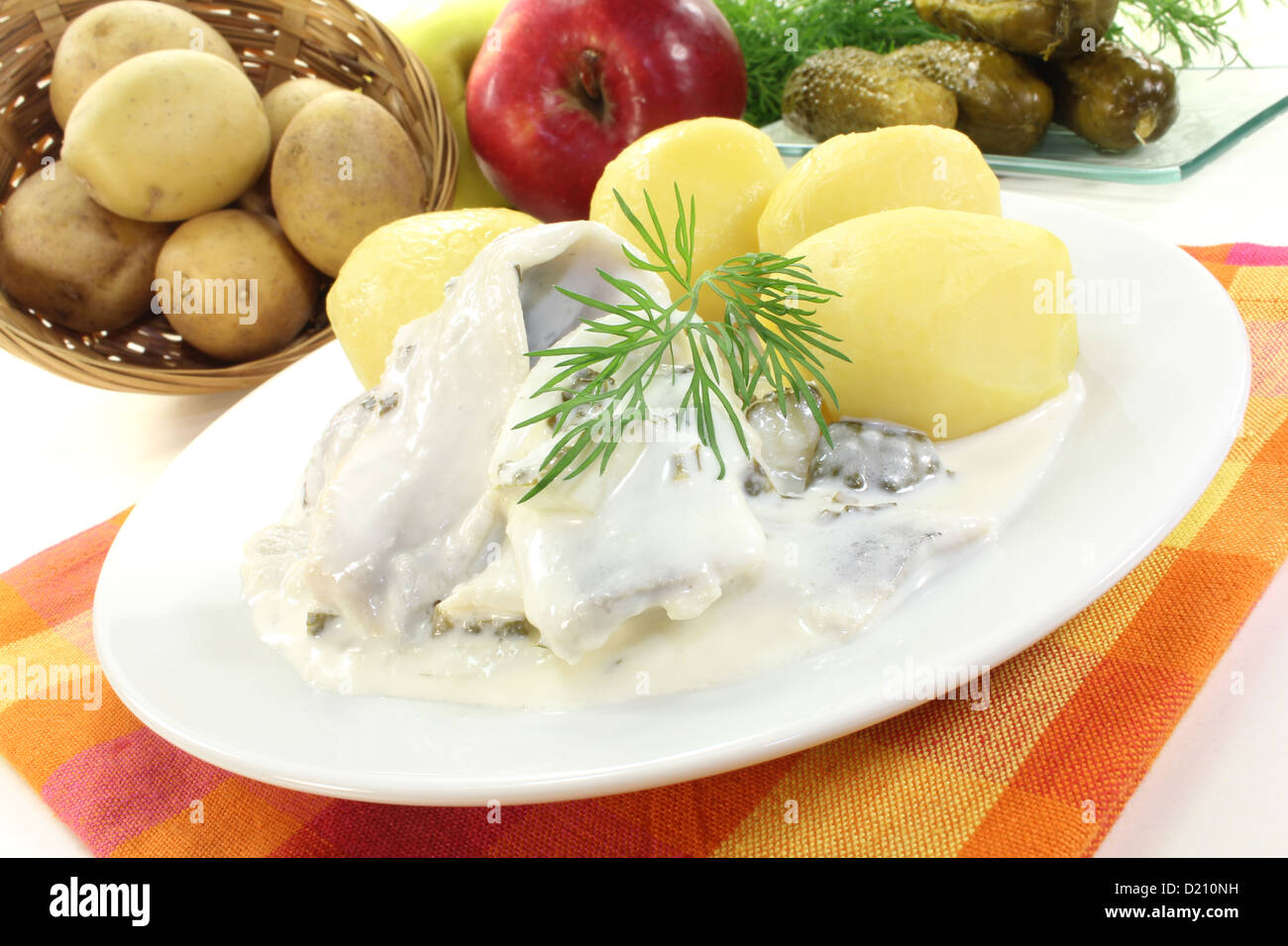 cream marinated herring with potatoes, cucumbers and dill Stock Photo