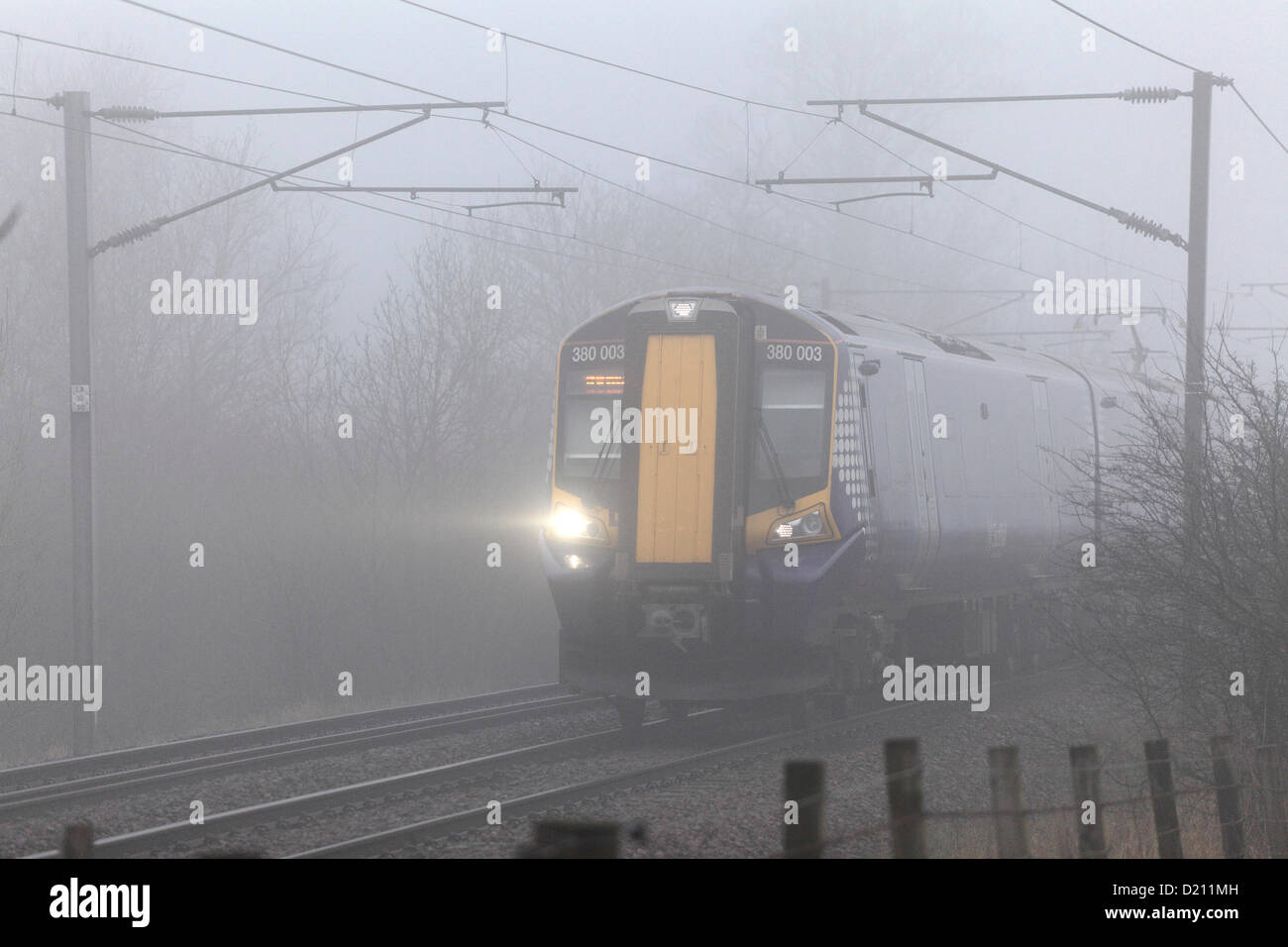 Renfrewshire, Scotland, UK, Thursday, 10th January, 2013. A Scotrail electric train travelling in fog on the Glasgow to Ayr line near Lochwinnoch. Stock Photo