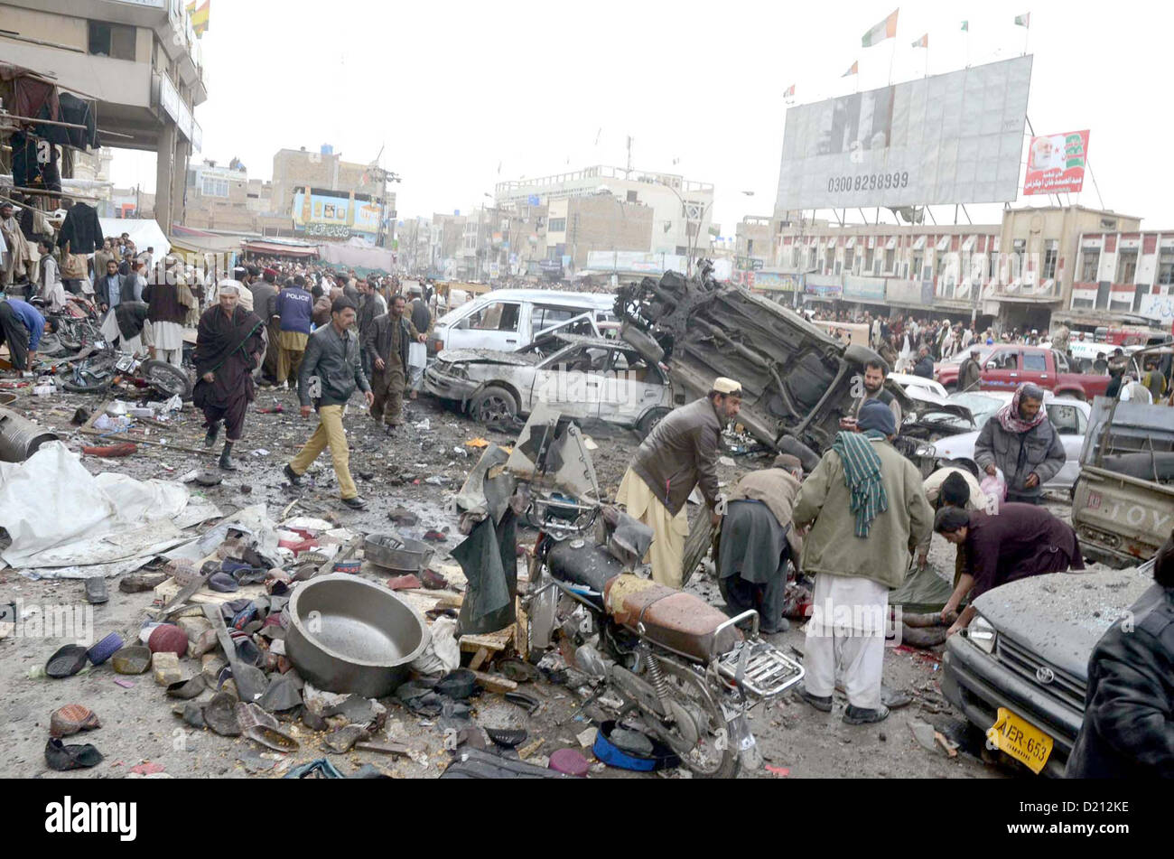 People gather at site after bomb blast at Bacha Khan Chowk in Quetta on Thursday, January 10, 2013. At least eleven people were killed and more than 50 including three FC personnel were injured in a powerful blast Bacha Khan square area. The bomb was planted in a car parked at Bacha Khan square on Iqbal-Avenue, which ripped through during busy hours in shopping area of the city. Stock Photo