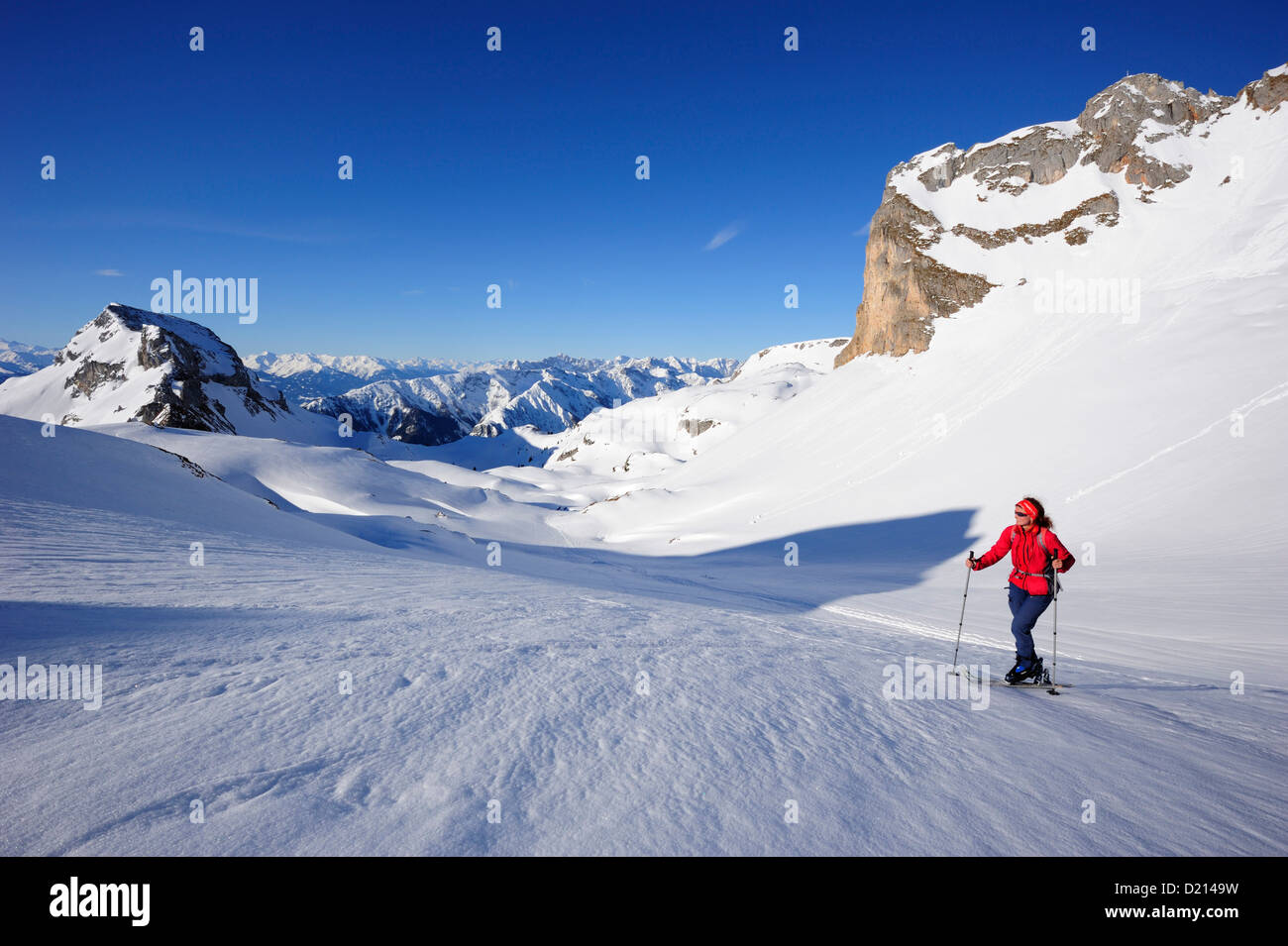 Woman with crosscountry skis ascending to Rofanspitze, Karwendel range in the background, Rofanspitze, Rofan, Tyrol, Austria, Eu Stock Photo