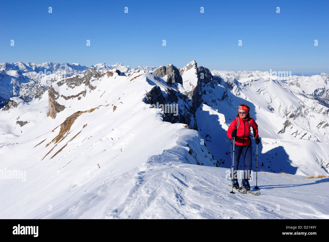 Woman with crosscountry skis ascending to Rofanspitze, Seekarlspitze, Hochiss and Karwendel range in the background, Rofanspitze Stock Photo