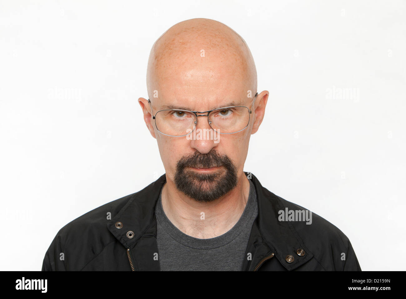 Portrait of a serious and unsmiling bald man against a white background. Stock Photo