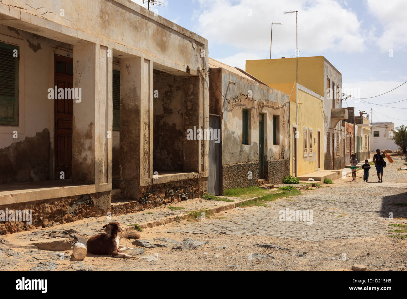 Ramshackle colonial buildings with dog in typical street scene in Sal Rei, Boa Vista, Cape Verde Islands, Africa. Stock Photo