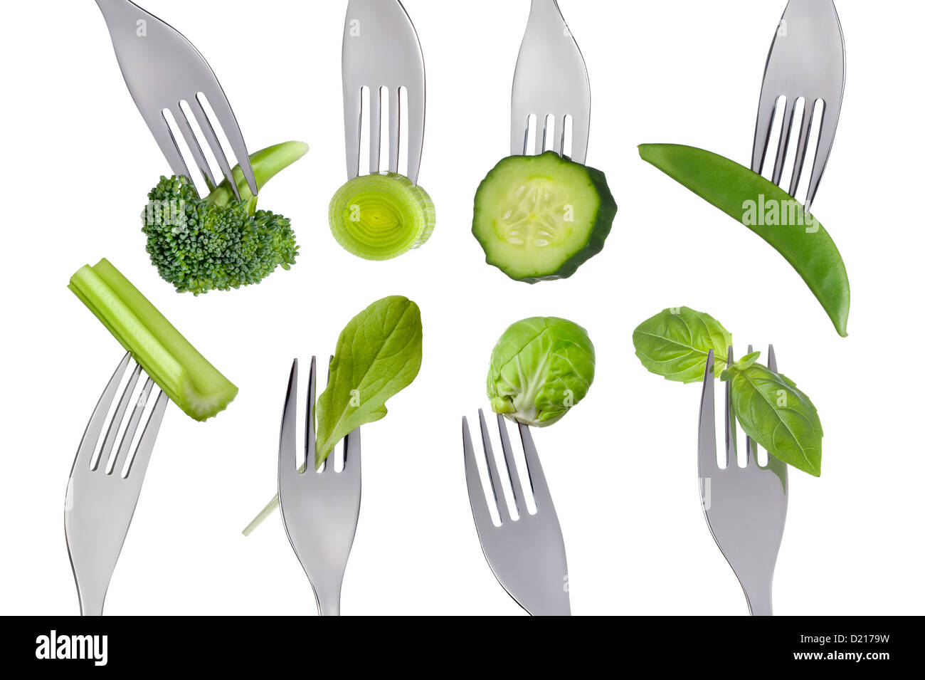 green healthy fresh food vegetables forks isolated white background: broccoli leek, cucumber mange tout celery lettuce basil Stock Photo