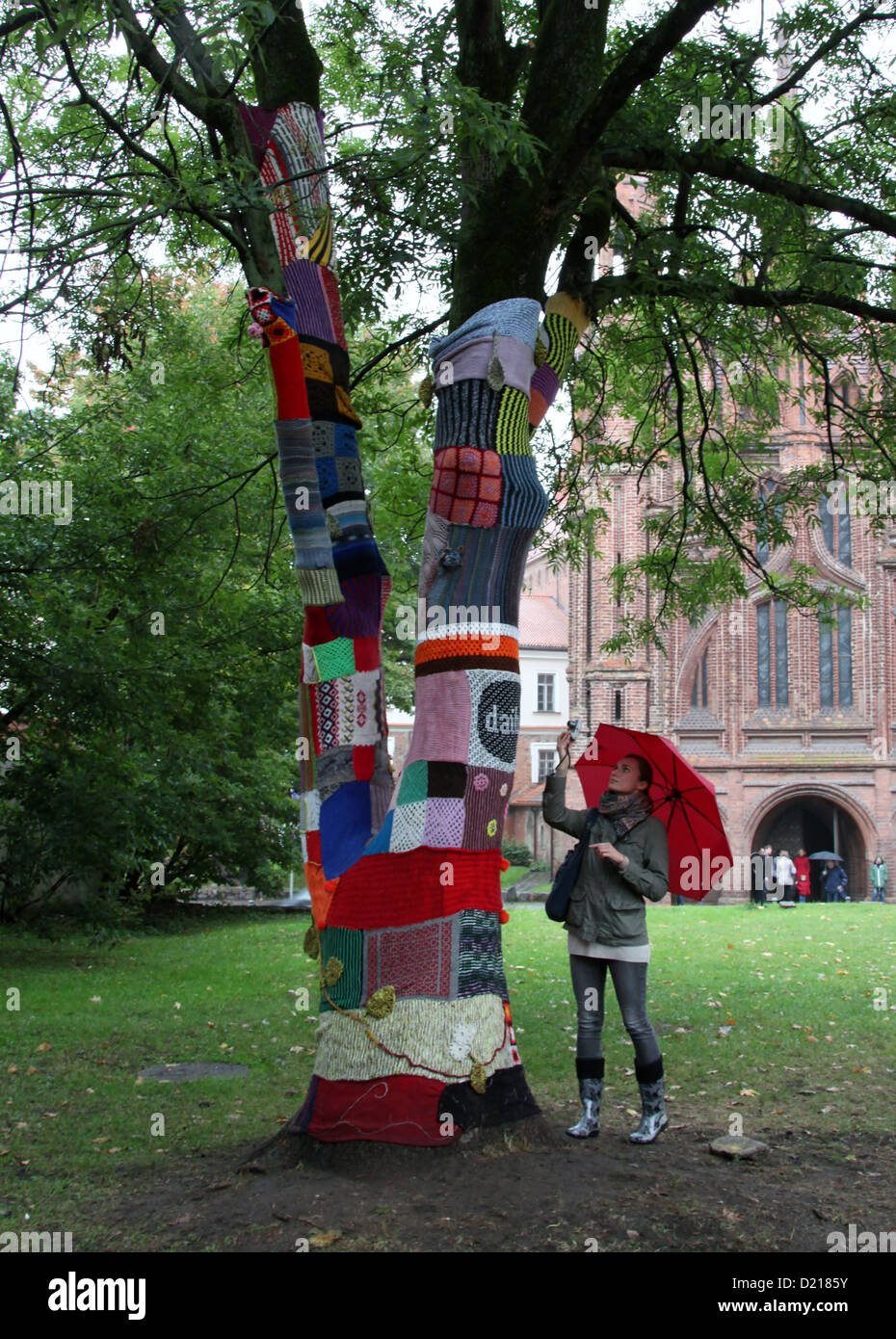 Girl with red umbrella photographing Urban Knitting in Vilnius Stock Photo