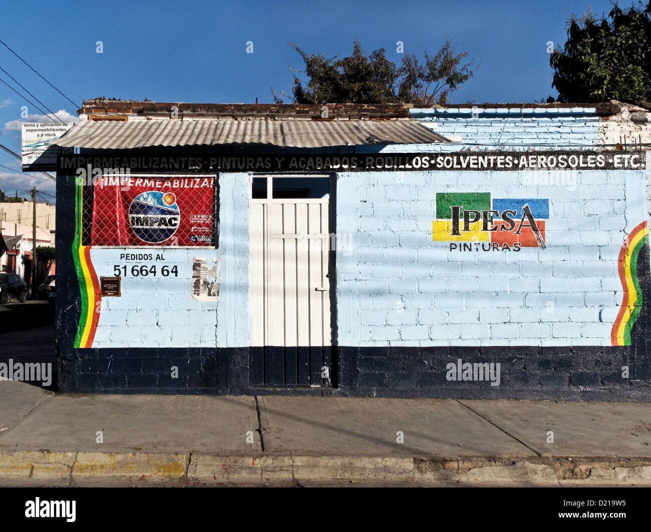 colorful painted masonry street facade & advertising on paint store shop with corrugated tin roof in Oaxaca de Juarez Mexico Stock Photo