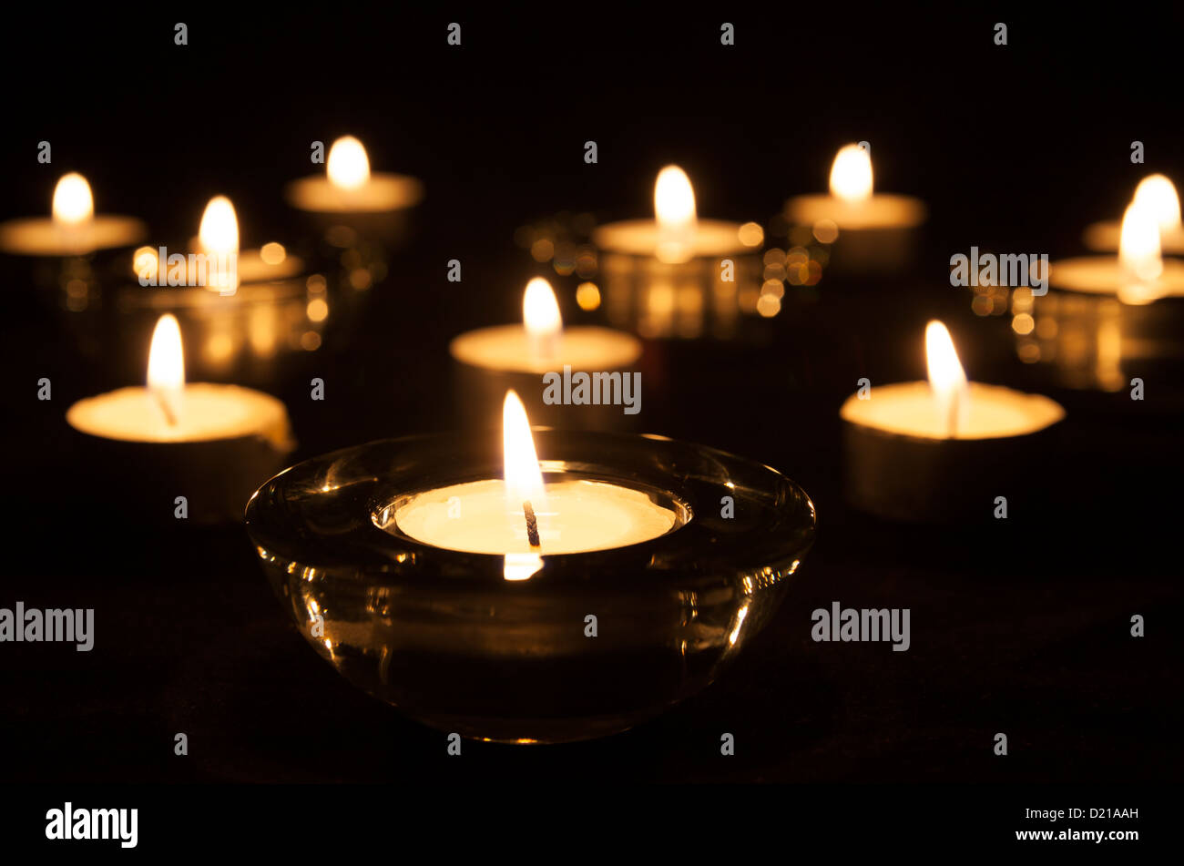 Lit tea lights in holders Stock Photo Alamy