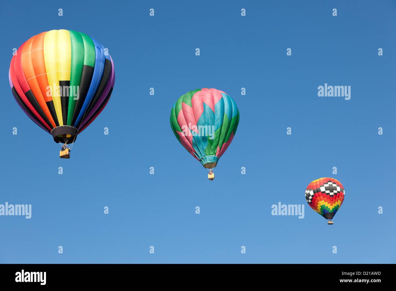 Three colorful hot air balloons floating into a blue sky Stock Photo ...