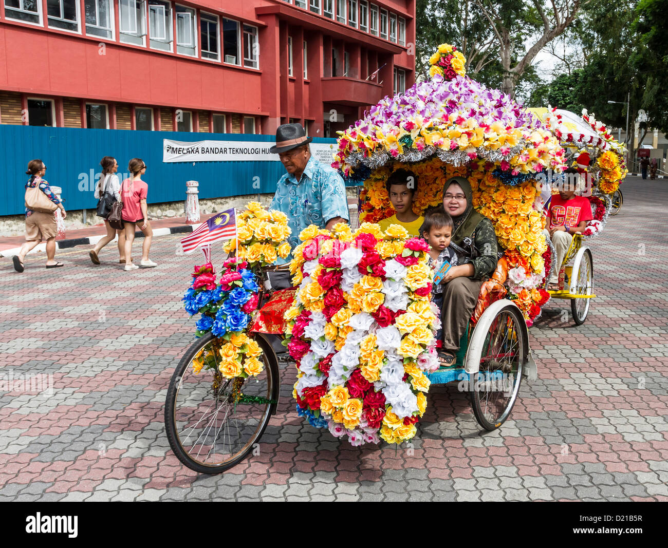 Tourists on trishaw ride in Melaka, Malaysia, are a popular tourist attraction Stock Photo