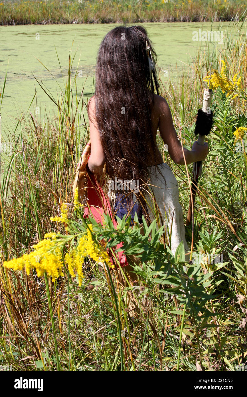 A Native American Indian Lakota Sioux boy with spear and shield hunting by a pond Stock Photo