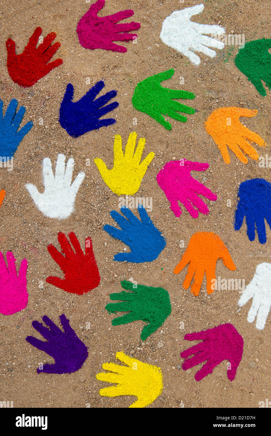 Coloured powder hand prints in a circular spiral pattern on a dirt track Stock Photo