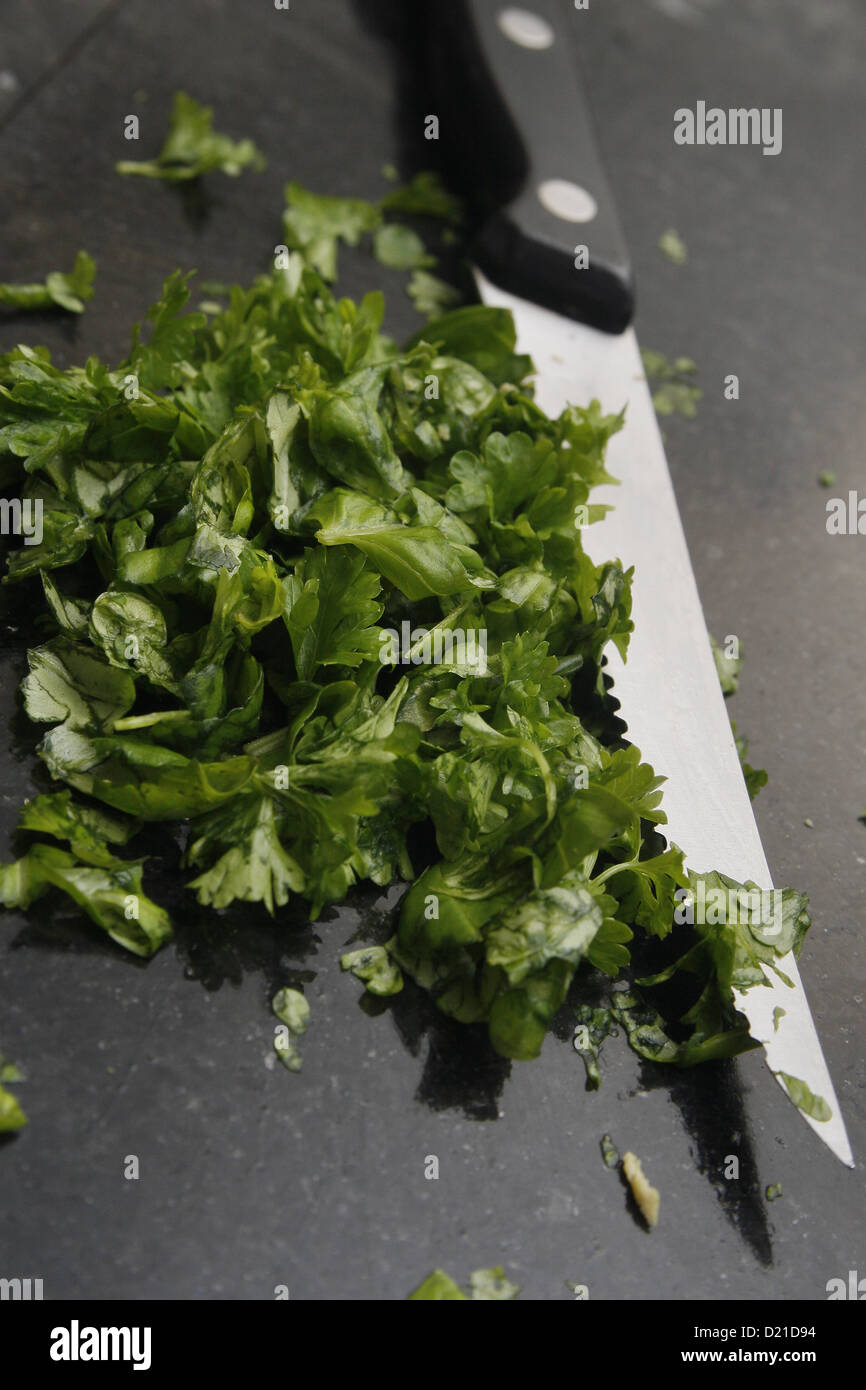 https://c8.alamy.com/comp/D21D94/chopped-up-basil-and-parsley-on-chopping-board-with-knife-D21D94.jpg
