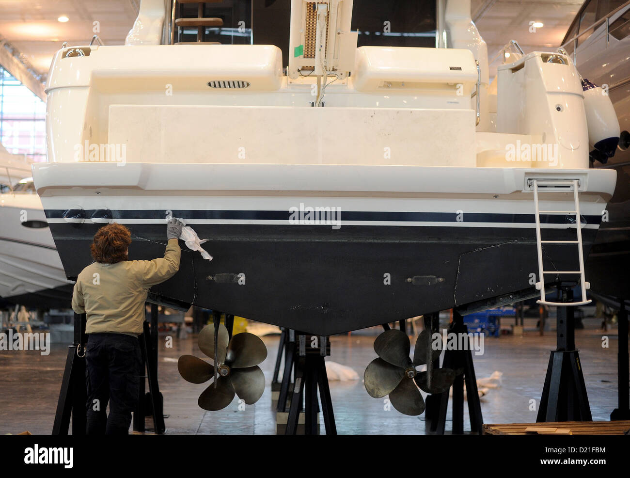 A man cleans the body of a yacht on the fair grounds in Duesseldorf, Germany, 10 January 2013. The 2013 Boat Fair takes place from 19 until 27 January. Photo JONAS GUETTLER Stock Photo