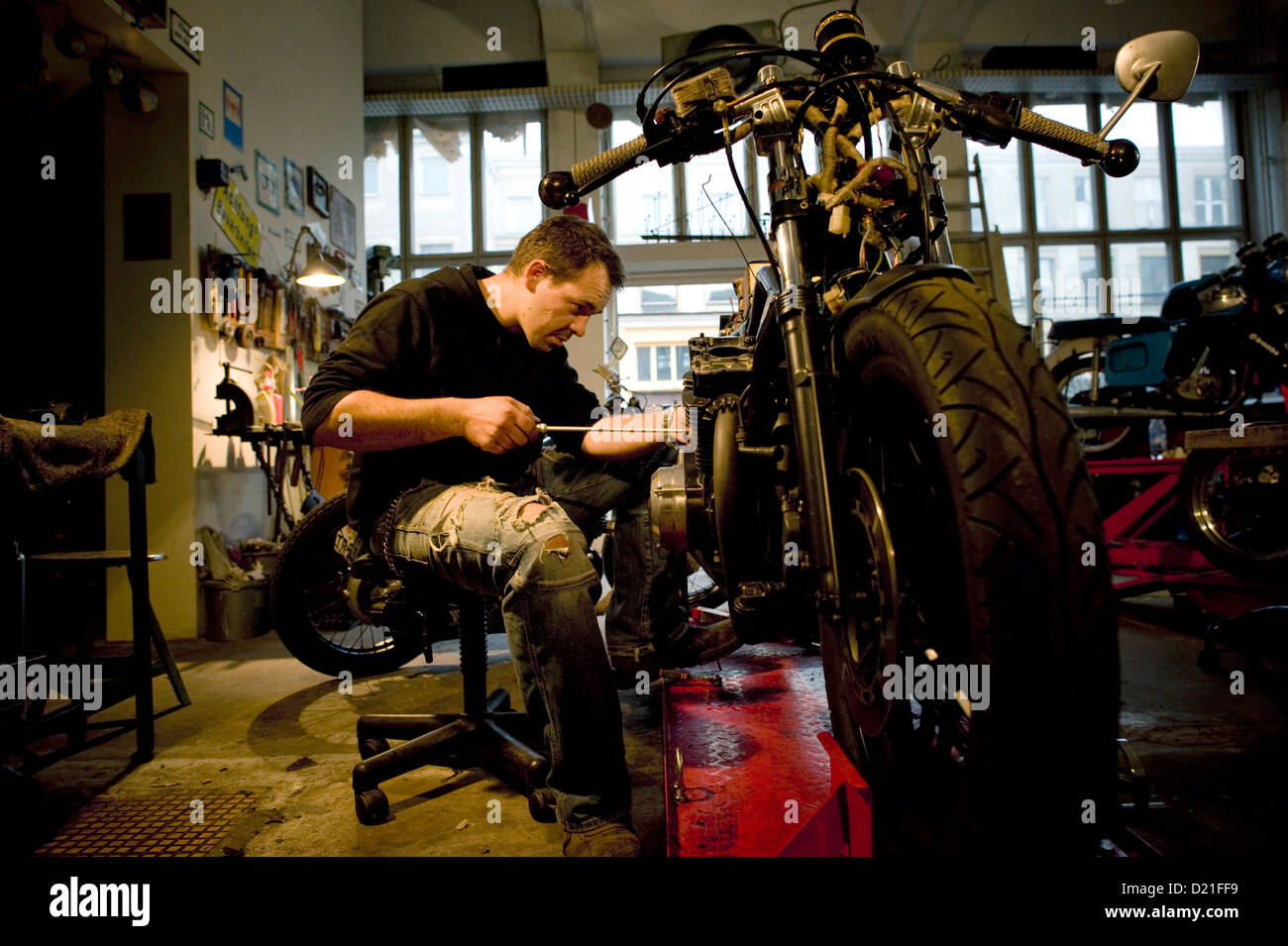 The owner of the garage "Dirty Bikes" works on a motor bike in Dresden