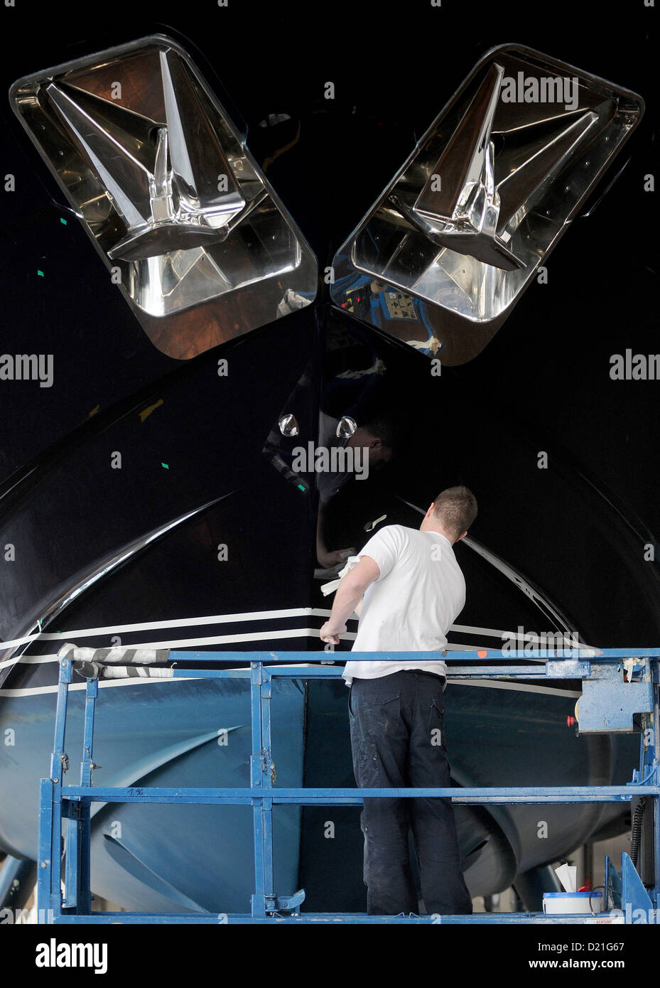 A man cleans the body of a yacht on the fair grounds in Duesseldorf, Germany, 10 January 2013. The 2013 Boat Fair takes place from 19 until 27 January. Photo JONAS GUETTLER Stock Photo
