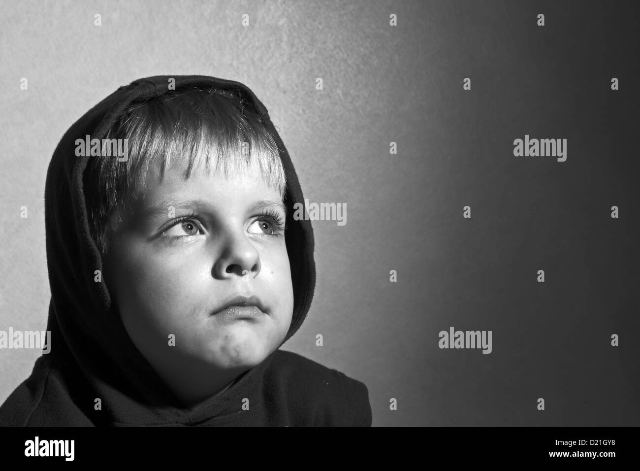 black and white photo of sad boy in the hood Stock Photo