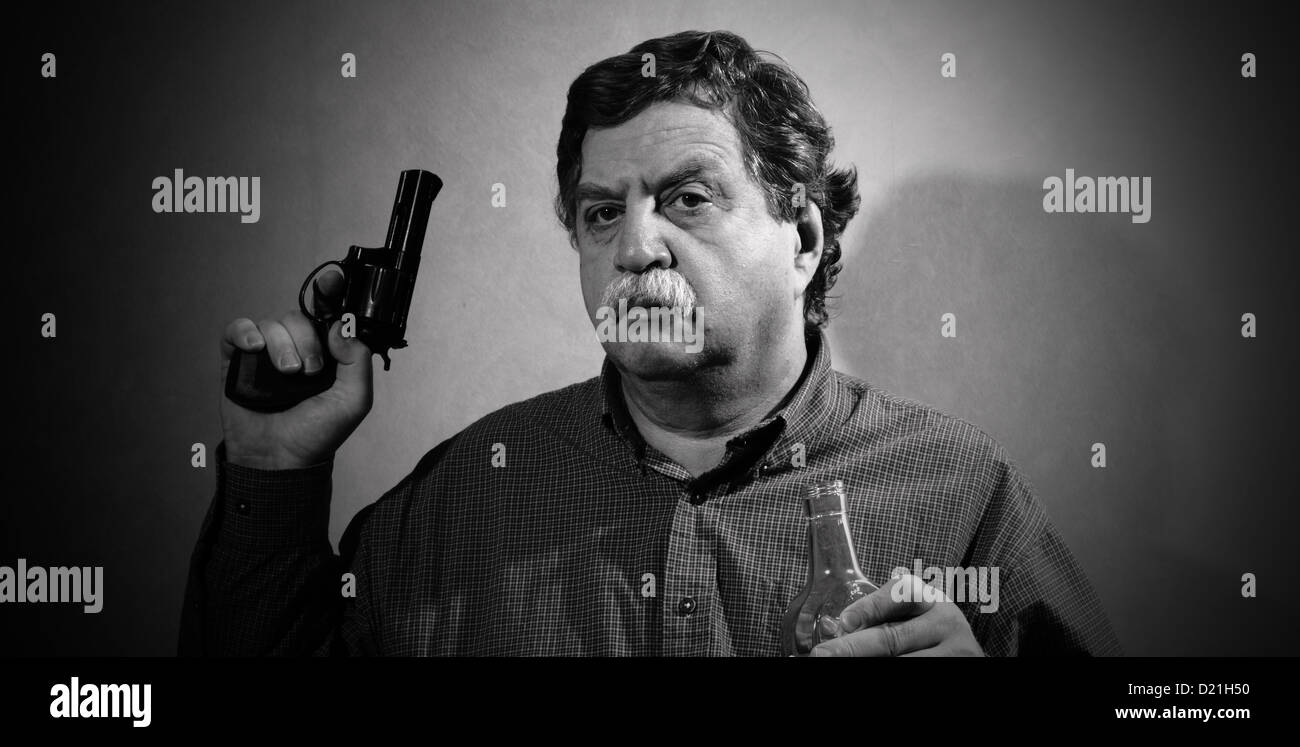 man holding a gun and a bottle of whiskey Stock Photo