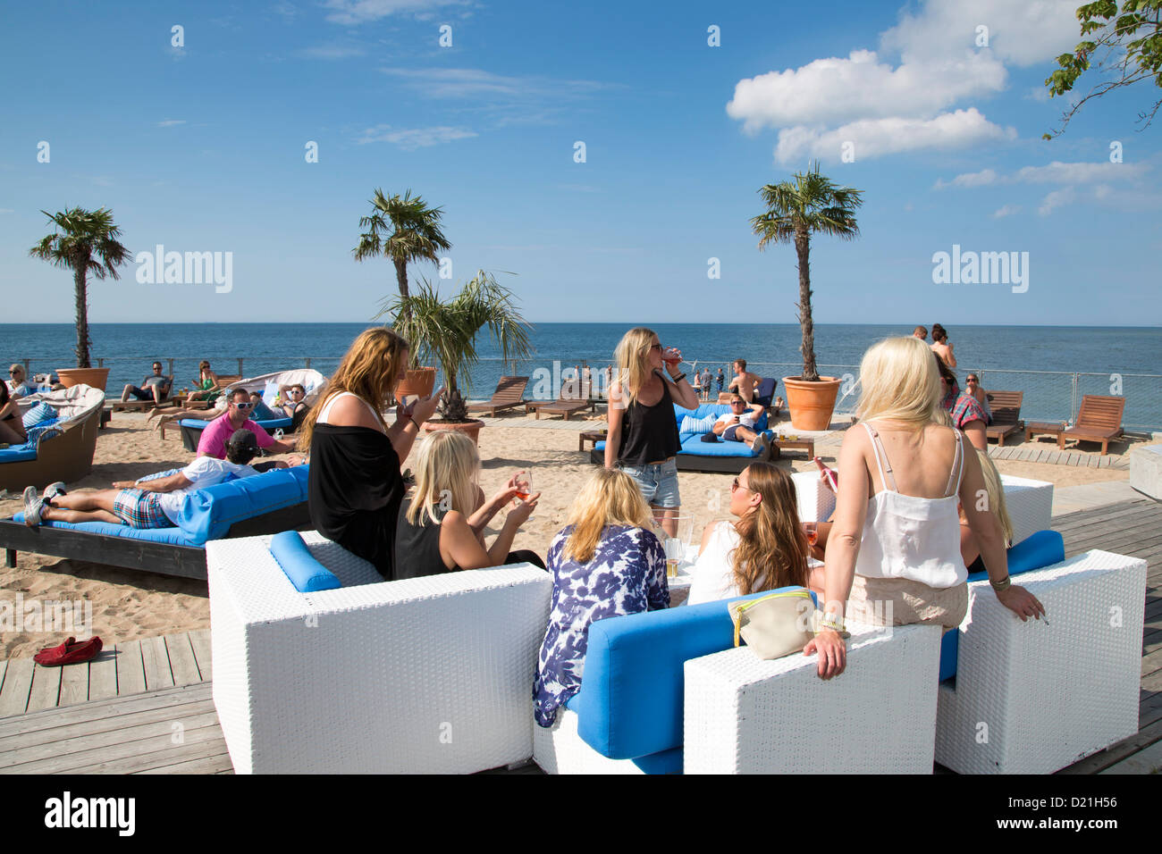 Young women relaxing on lounge chairs at the trendy Kallis Beach Club, Visby, Gotland, Sweden, Europe Stock Photo