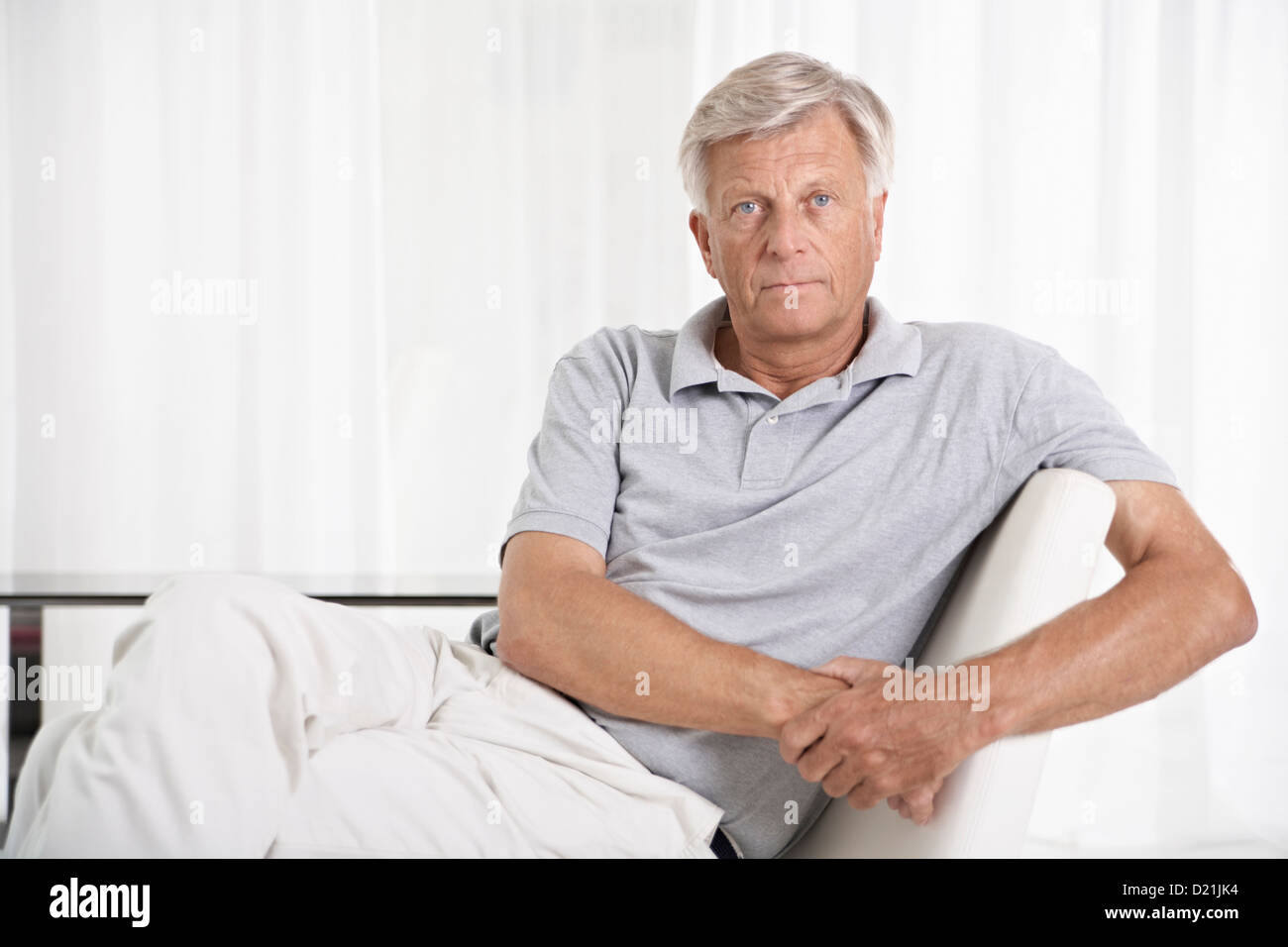 Spain, Mallorca, Sad senior man sitting on couch Stock Photo - Alamy