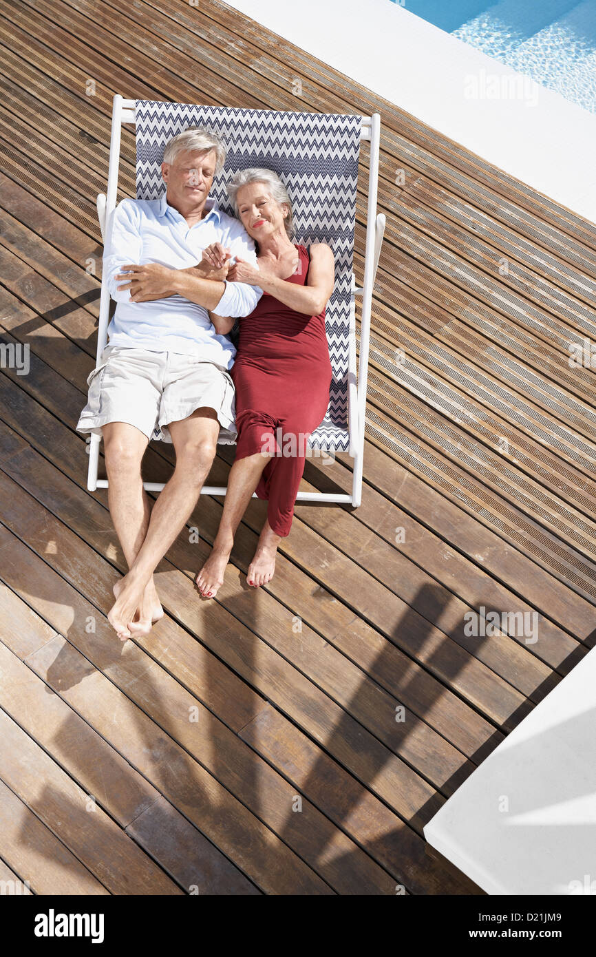 Spain, Senior couple relaxing on deck chair at beach Stock Photo - Alamy