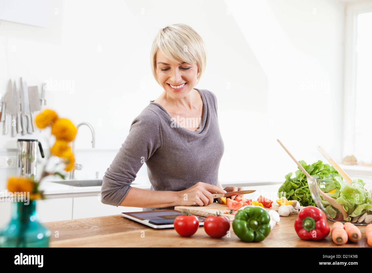 Germany, Bavaria, Munich, Woman preparing food in kitchen Stock Photo