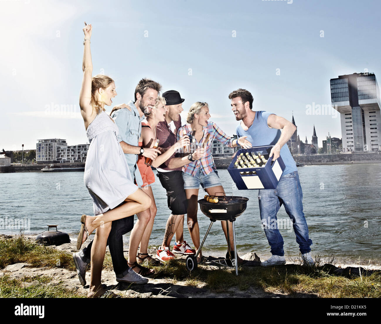 Germany, Cologne, Group of people gathered around barbecue Stock Photo