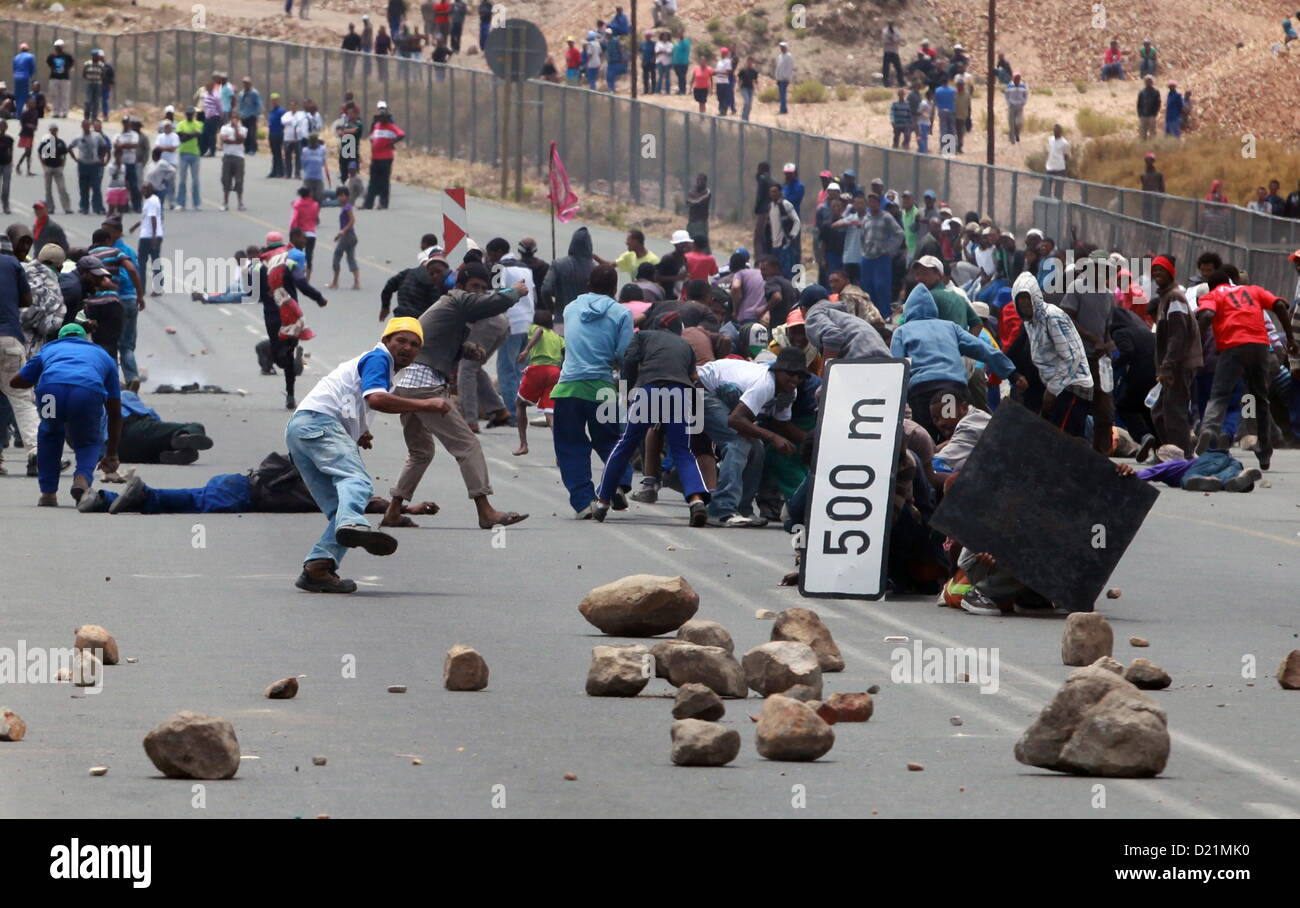 GRABOUW, SOUTH AFRICA: Farm workers scatter as police fire rubber bullets to  stop them making barricades to block off the N2 on January 10, 2013 in Grabouw, South Africa. Seasonal farm workers are striking over wage disputes.  (Photo by Gallo Images /  Nardus Engelbrecht) Stock Photo
