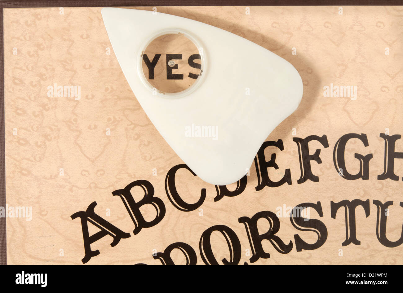 Ouija board with the planchette pointing to YES. This is the vintage Ouija board and classic arrangement of the letters. Stock Photo