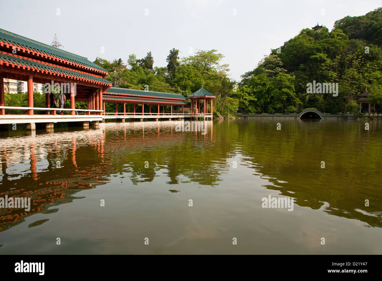 An ancient Chinese style bridge across the lake in Xishan Park in Guilin City in Guangxi Province in Southern China. Stock Photo