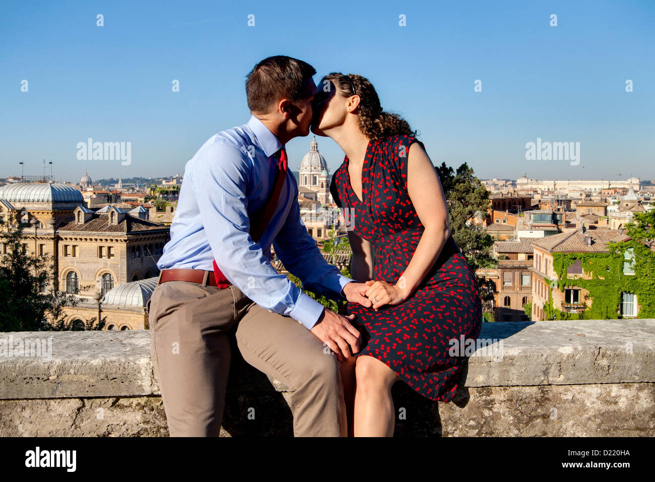 Couple kissing over the roman rooftops Stock Photo