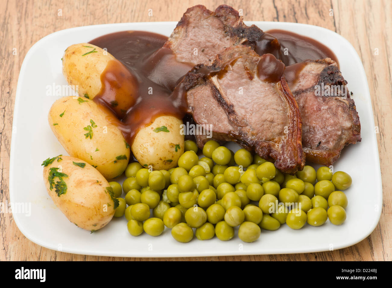 Lamb chops with peas, potatoes and gravy studio shot Stock Photo Alamy