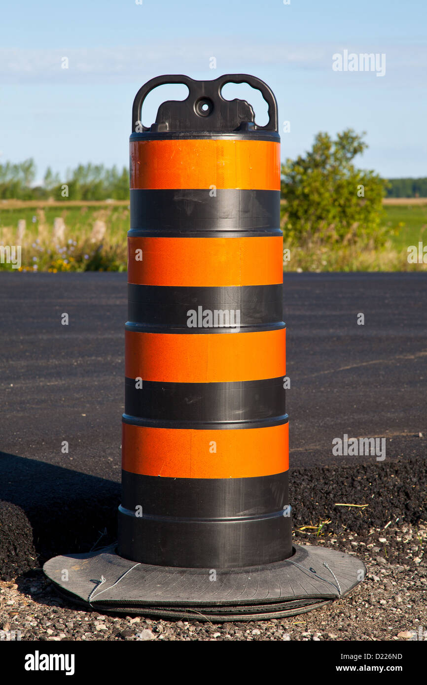 A large striped pylon such as those used in highway construction. Stock Photo