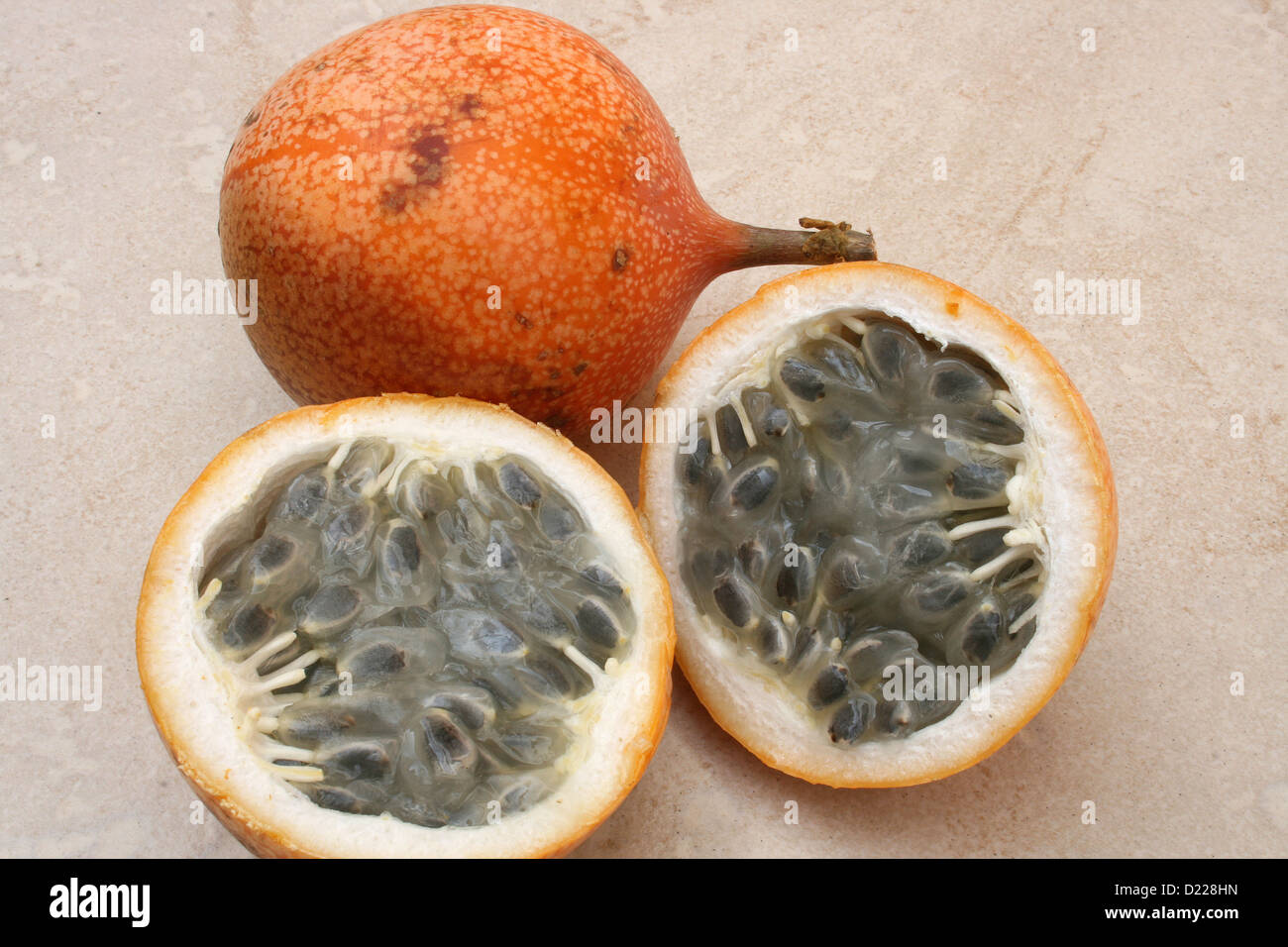 Granadilla fruit has a hard shell and soft pulp with seeds and is grown locally in Cotacachi, Ecuador Stock Photo