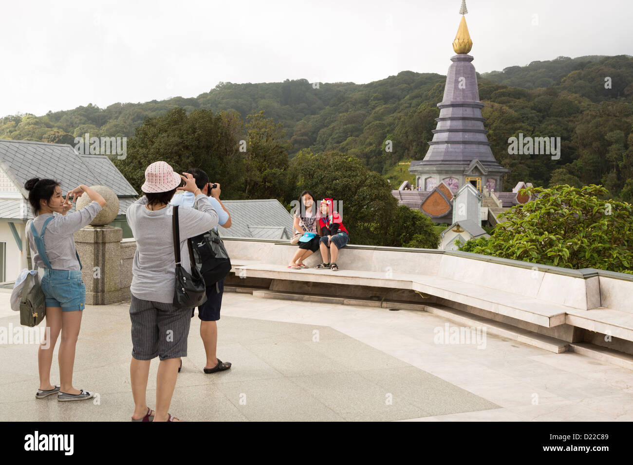 Asian tourists posing in front of the Naphaphonphumisiri Chedi on the top of Doi Inthanon, the highest mountain in Thailand Stock Photo