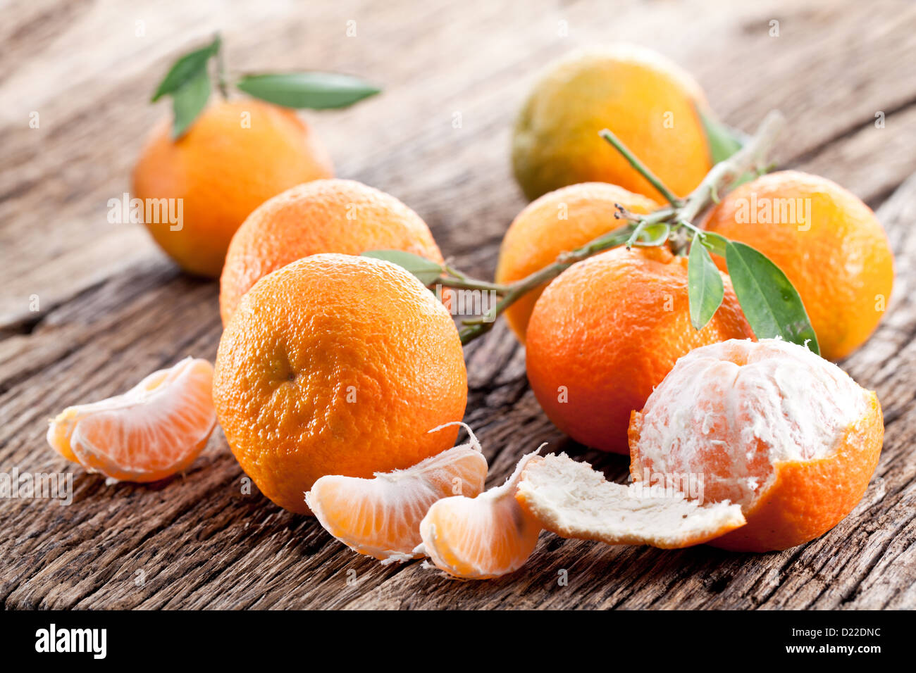 Tangerines with leaves on a wooden table. Stock Photo