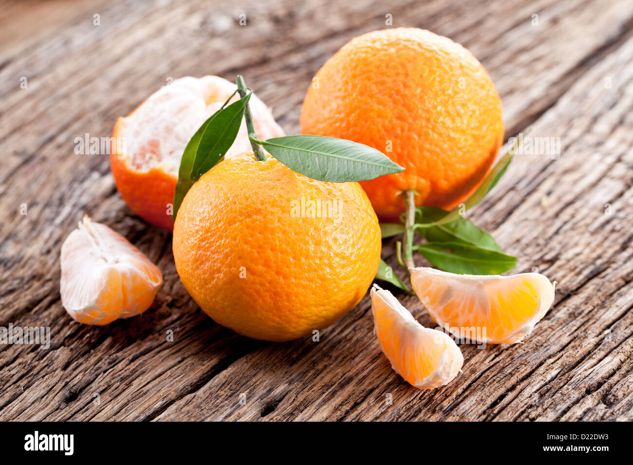 Tangerines with leaves on a wooden table. Stock Photo