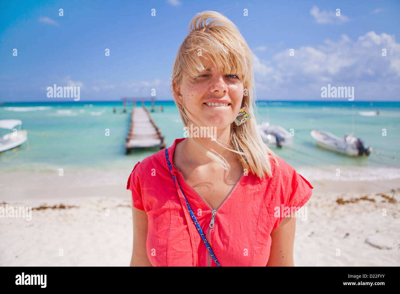 Young woman standing on the beach Stock Photo - Alamy
