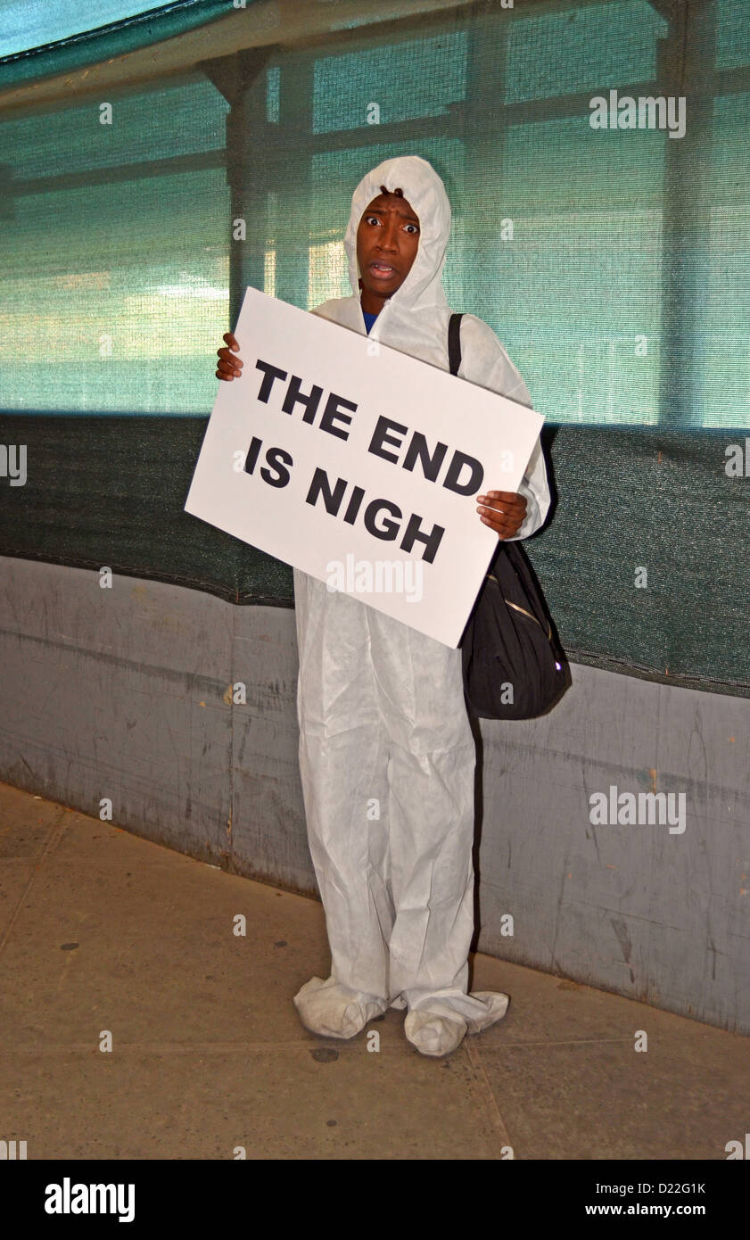 Portrait Erin in white with sign reading 'The End is Nigh' at Comicon in New York City. Stock Photo