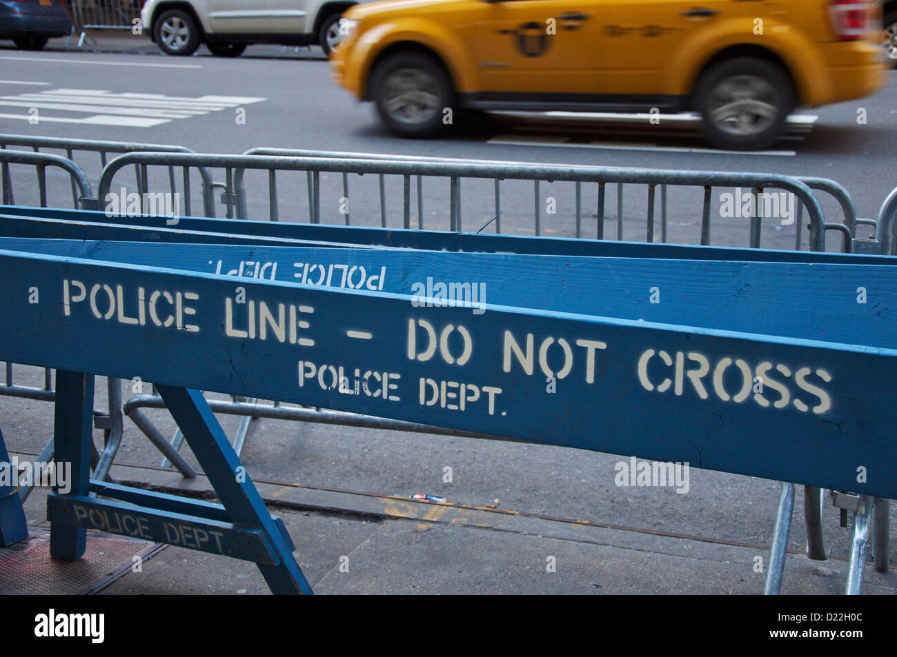 Street scene in New York: Police barriers and moving taxi Stock Photo