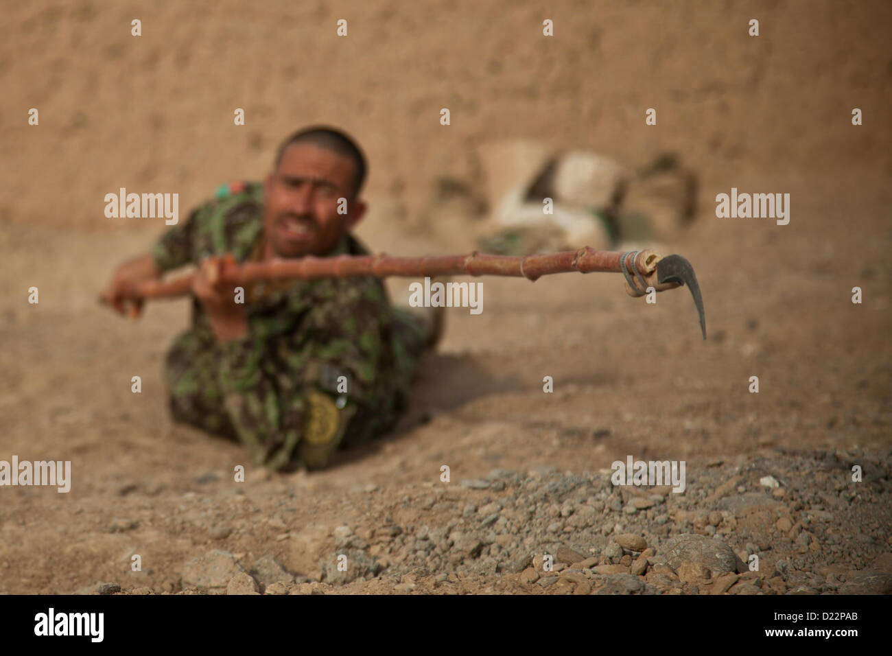 An Afghan National Army Soldier attempts to identify a notional improvised explosive device during training with fellow Afghan National Security Forces in Farah province, Afghanistan, Jan. 11, 2013. Afghan National Security Forces have been taking the lead in security operations, with coalition forces as mentors, to bring security and stability to the people of the Islamic Republic of Afghanistan. (U.S. Marine Corps photo by Sgt. Pete Thibodeau/Released) Stock Photo