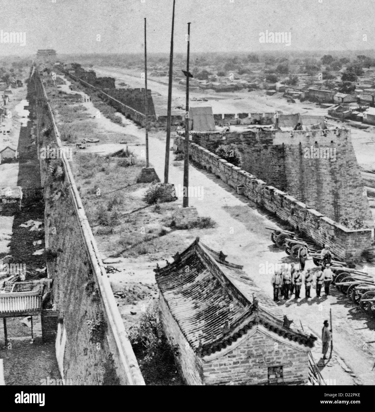 The Wall of Peking guarded by the Russian artillery, China - Russian soldiers and cannons assembled on the Beijing city wall, circa 1900 Stock Photo
