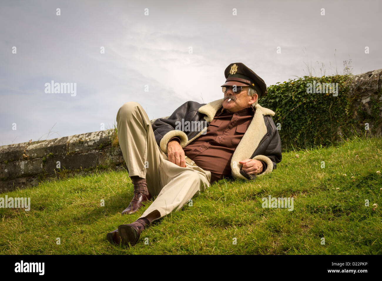 Air Force Pilot in Vintage Costume with cigarette on grass. Stock Photo