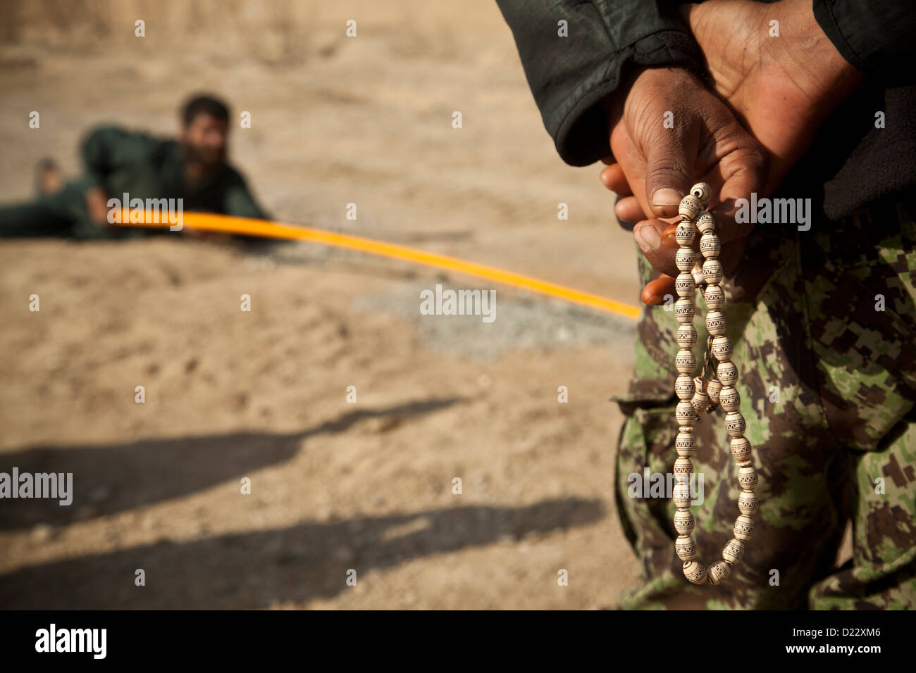 An Afghan National Army Soldier watches an Afghan Local Policeman conduct counter improvised explosive device training in Farah Stock Photo