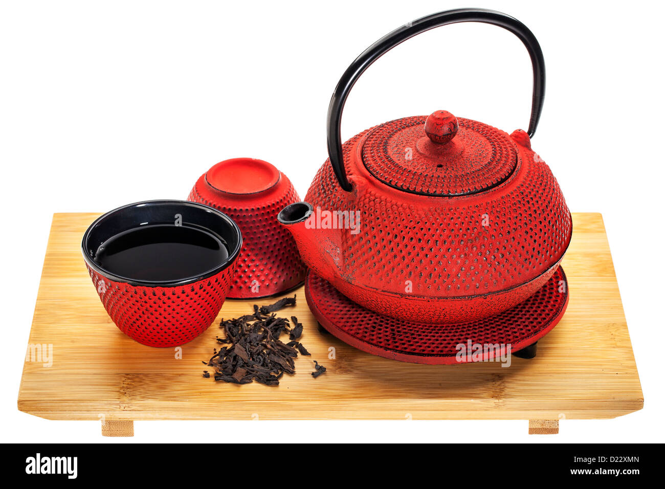 red hobnail tetsubin (traditional cast iron Japanese teapot) with a cup of oolong tea on a bamboo tray Stock Photo