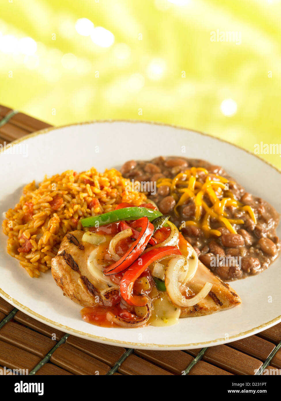 Grilled chicken topped with fajita vegetables and served with refried