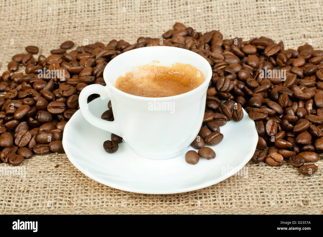 Cup of coffee and coffee beans on burlap Stock Photo