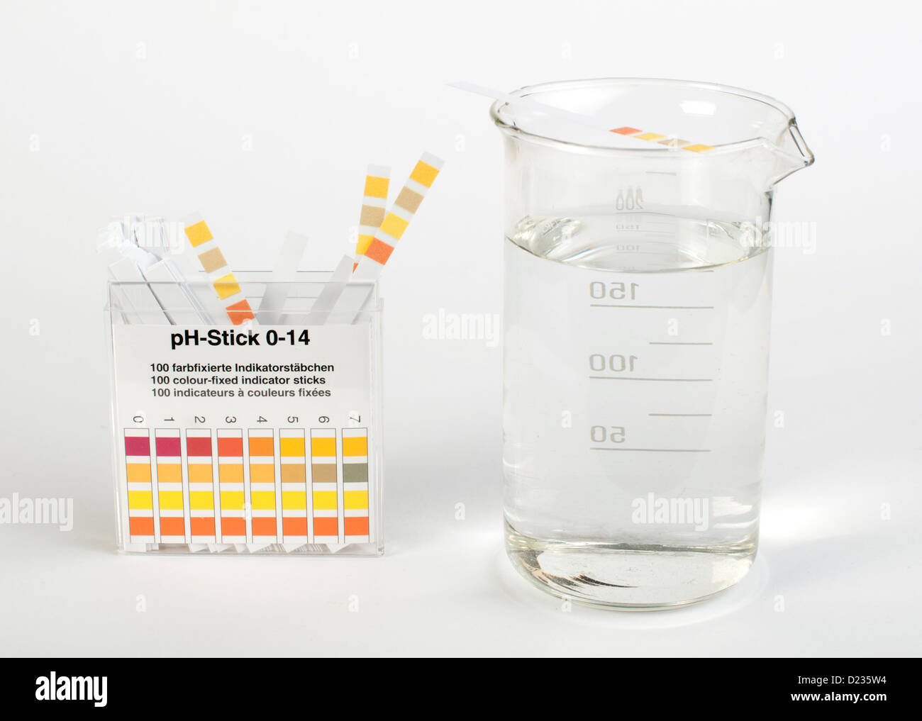 Litmus strips for measurement of acidity.Beaker with water Stock Photo