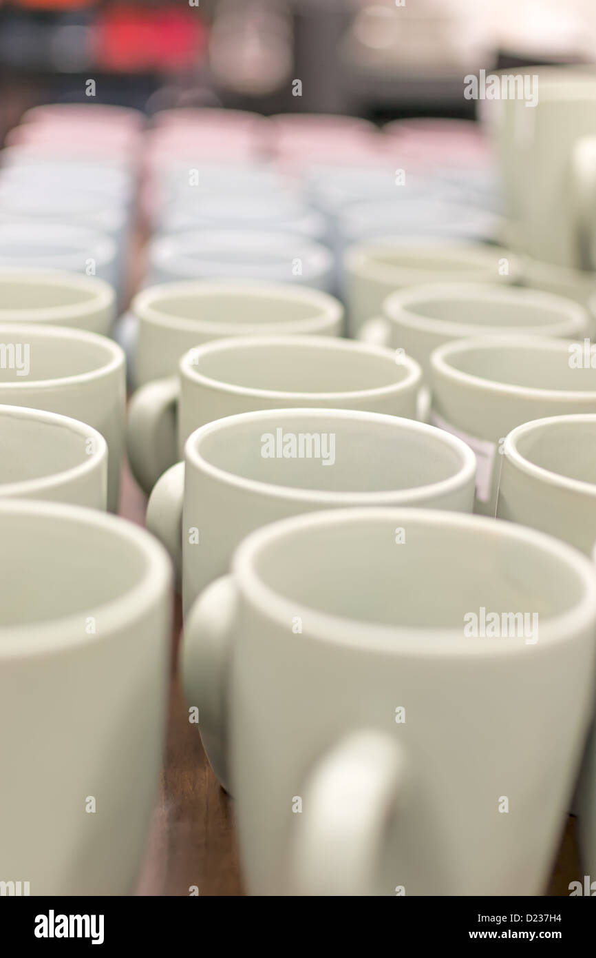 Many coffee mugs in a line over a buffet Stock Photo Alamy