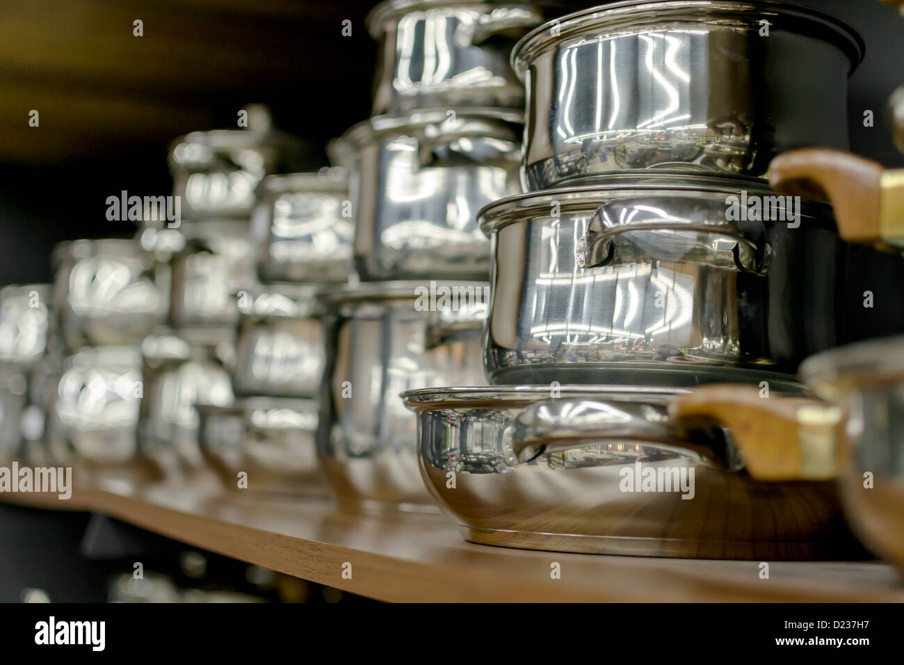 Stainless steel pots on wooden shelf Stock Photo